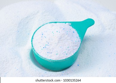 Laundry detergent powder for washing machine and plastic scoop for dosage.