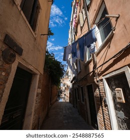 Laundry is dried on clotheslines above an alley in Venice - Powered by Shutterstock