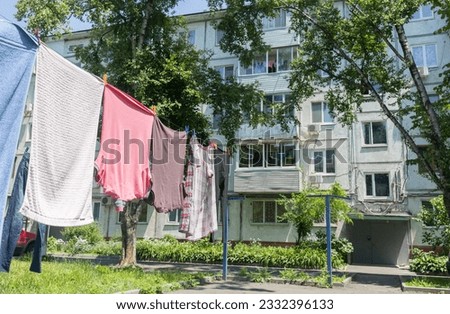 Laundry dries on washing line in courtyard of Khrushchyovka, a common type of old low-cost apartment building in Russia and post-Soviet space. Life in Russia. Russia, Vladivostok.