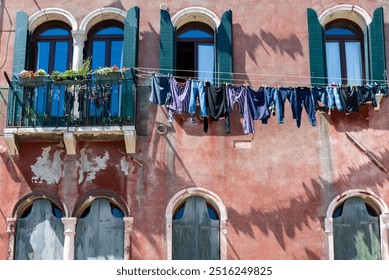 Laundry hanging from a clothes line outside a window on the street in Venice, Italy - Powered by Shutterstock