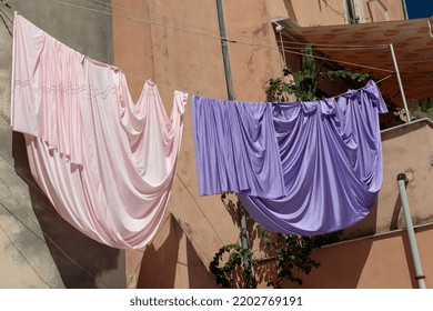 Laundry Hung Against The Backdrop Of Historic Stonework In Greece. Everyday Life In The City