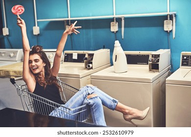 Laundry, portrait and woman in shopping cart, smile and chores with washing machine, cool and cleaning. Fashion, waiting and person with lollipop, relax and fun in laundromat, happy and weekend - Powered by Shutterstock