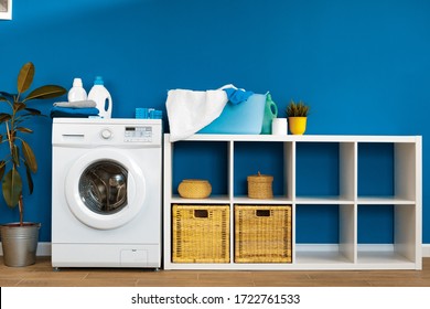 Laundry room. Close up of washing machine against blue wall