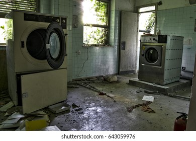 A Laundry Room With A Dirty Floor And Broken Things On It, In An Abandoned Psychiatric Hospital.