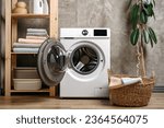 Laundry room interior with washing machine near gray grunge wall