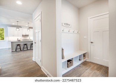 Laundry room and mud room waiting area coat rack hooks baskets shoes washing machine dryer cabinets cupboards interior home - Shutterstock ID 2275487523
