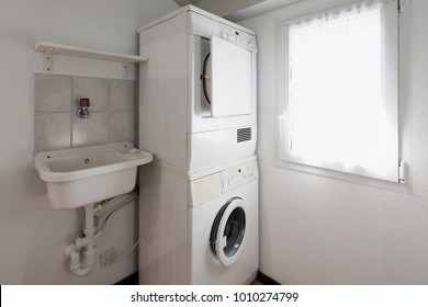 Laundry With Washer And Dryer Stacked On Top Of Each Other. 