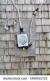 Laurel, DE-USA-January 10, 2021:  An Antique Meter Hangs On For Dear Life To An Abandoned Weathered Derelict Home.  Meter Is Obsolete, A Victim Of The Weather And Jury Rigged.