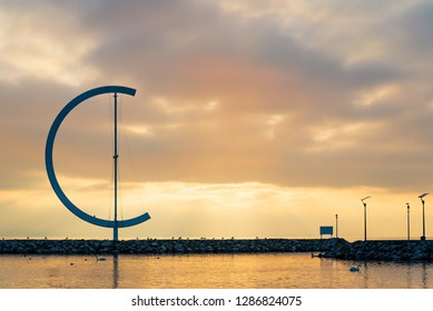 Lausanne, Switzerland - DECEMBER 2018: Dramatic tranquil silhouette  beautiful sunset at Geneva lake with background of embankment and sculptural landmark in Lausanne, Switzerland.