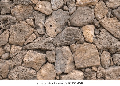 Lava Rock Exterior Wall With Pattern/texture In Tones Of Brown,tan,red, And Gray/grey.