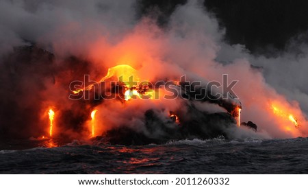 Lava running in the ocean from volcanic lava eruption on Big Island Hawaii. Seen from lava boat tour. Lava from Kilauea volcano by Hawaii volcanoes national park, USA.