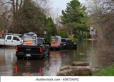 LAVAL, QUEBEC-CANADA - MAY 6TH 2017:  Disastrous floods in Laval-on-the-Lake Quebec, Canada. Trucks filled with sand bags moving into the flooded street.