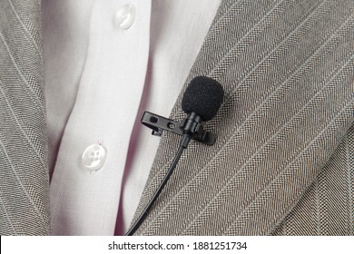 The Lavalier Microphone Is Secured With A Clip On A Women's Shirt Close-up. Audio Recording Of The Sound Of The Voice On A Condenser Microphone