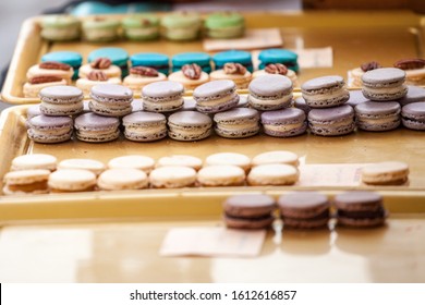 Lavander Flavored Purple Macarons On Display In A French Pastry Shop Among Other Macaroons. Macaron Is A Traditional Biscuit And Cake From France, A Symbol Of Gastronomy.

