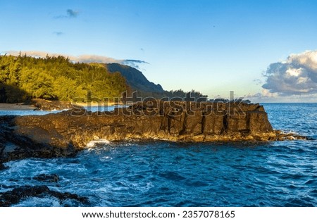 Lave rocks and pools by Lumaha'i beach on Hawaiian island of Kauai with Na Pali mountains behind. Taken at dawn