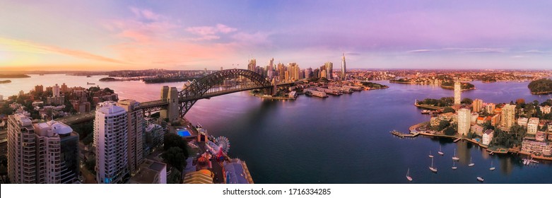 Lavender bay on Sydney Harbour in front of city CBD and major landmarks in wide aerial panorama at sunrise.