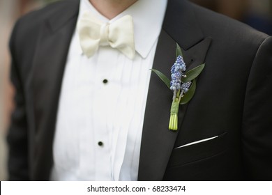Lavender boutonniere flower on suit jacket of wedding groom