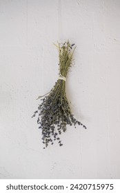 Lavender bundle drying against white wall