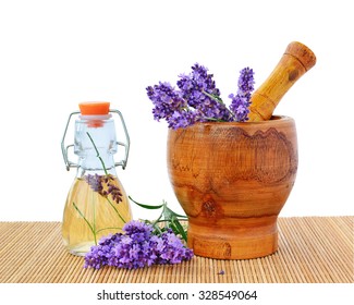Lavender essential oil with lavender flowers in wooden mortar.