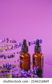 Lavender Essential Oil.Brown Glass Bottles Oil Set And Lavender Flowers On A Purple Background.aroma Of Lavender.Essence With Lavender Scent. 