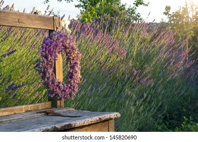 Lavender Flower Wreath On A Wooden Old Bench In A Summer Garden