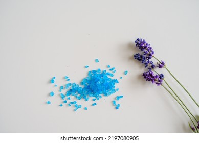 Lavender Flowers And Bath Salt. Blue Heart Of Lavender Bath Salt. Flat Lay Bath Salt, Spa Products And Lavender Flowers On White Background. Skin Care, Beauty Treatment Concept. Copy Space. 