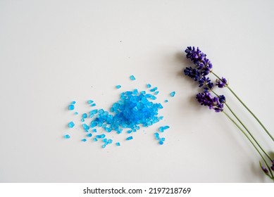 Lavender Flowers And Bath Salt. Blue Heart Of Lavender Bath Salt. Flat Lay Bath Salt, Spa Products And Lavender Flowers On White Background. Skin Care, Beauty Treatment Concept. Copy Space. 