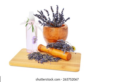 Lavender flowers in mortar, hydrosol bottle on wooden board isolated on white background.