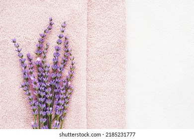 Lavender flowers and pink fluffy towels on the light background. SPA, wellness well-being, body care concept. Copy space for text, top view - Powered by Shutterstock