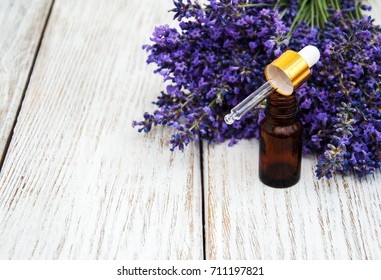 Lavendelöl mit frischem Lavendel auf Holzhintergrund