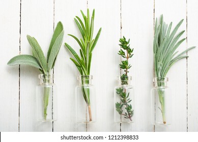 lavender, thyme and sage fresh herbal leaves in mini glass bottles, white wood table background - Shutterstock ID 1212398833