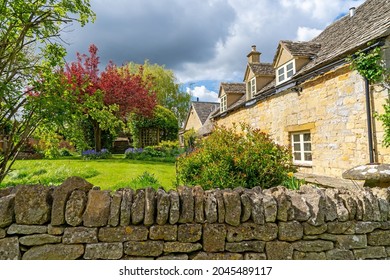 Laverton, Gloucestershire, UK, May 5th, 2021, Stone built cottage and garden with boundary wall in this pretty Cotswold village. 