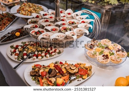  lavish buffet display with multiple tiers of appetizers, salads, and small gourmet dishes. The spread includes beautifully arranged food items, designed to impress guests at a formal event.