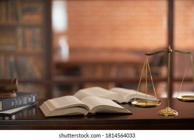 law books and scales of justice on desk in library of law firm. jurisprudence legal education concept.