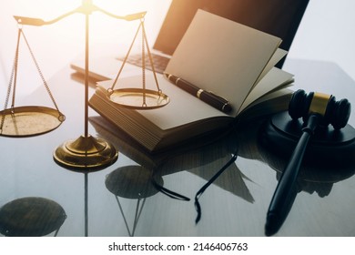 law books and scales of justice on desk in library of law firm. jurisprudence legal education concept. - Powered by Shutterstock