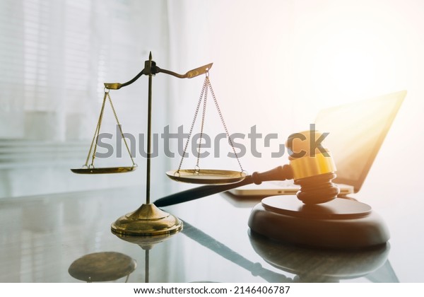 law books and\
scales of justice on desk in library of law firm. jurisprudence\
legal education concept.
