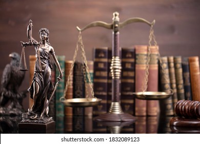 Law concept. Justice symbols on wooden background. Scales, themis, gavel, hourglass, books.
