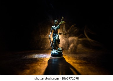 Law concept. Miniature colorful artwork decoration with fog and backlight. The Statue of Justice - lady justice or Iustitia  Justitia the Roman goddess of Justice. Selective focus