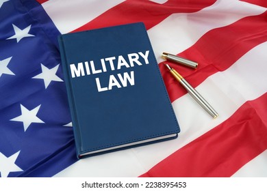 Law concept. On the US flag lies a pen and a book with the inscription - MILITARY LAW - Shutterstock ID 2238395453