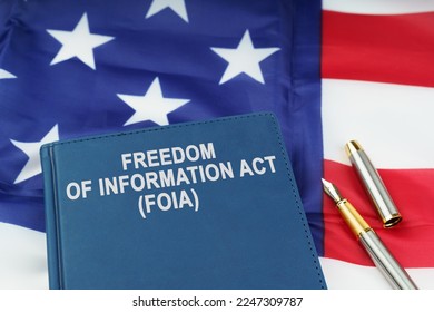 Law concept. On the US flag lies a pen and a book with the inscription - FREEDOM OF INFORMATION ACT - FOIA