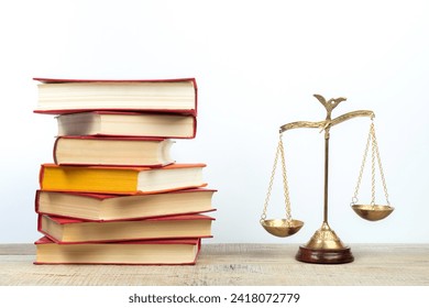 Law concept - Open law book, Judge's gavel, scales, Themis statue on table in a courtroom or law enforcement office. Wooden table, white background.