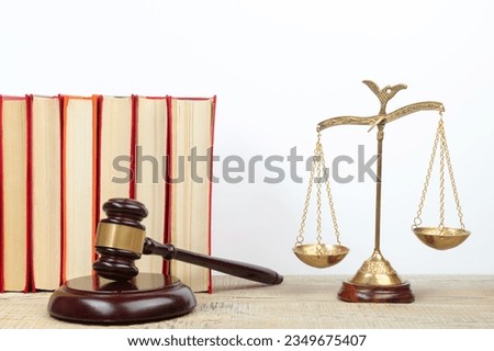 Law concept - Open law book, Judge's gavel, scales on table in a courtroom or law enforcement office.