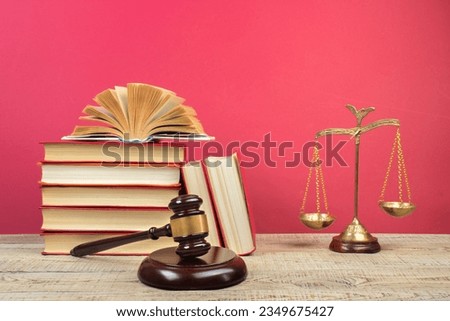 Law concept - Open law book, Judge's gavel, scales on table in a courtroom or law enforcement office.