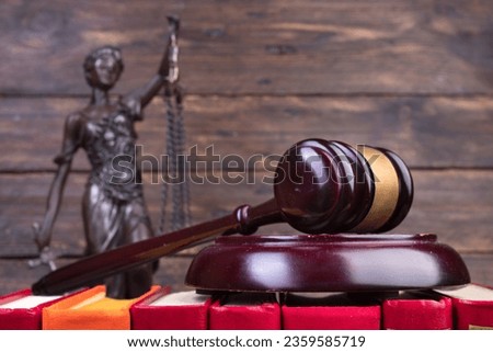 Law concept - Open law book, Judge's gavel, scales, Themis statue on table in a courtroom or law enforcement office. wooden background.