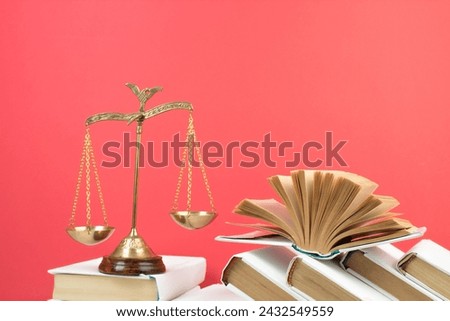 Law concept - Open law book, Judge's gavel, scales, Themis statue on table in a courtroom or law enforcement office. Wooden table, red background