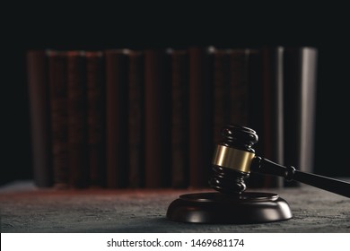 Rechtskonzept - Offenes Rechtsbuch mit Holzrichtern, die in einem Gerichtssaal oder einer Strafverfolgungsbehörde auf blauem Hintergrund auf dem Tisch liegen.