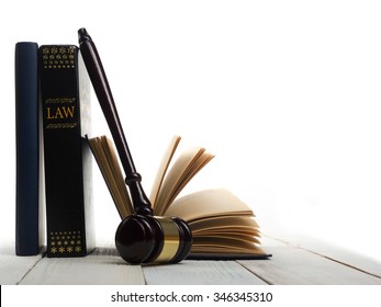 Law concept - Open law book with a wooden judges gavel on table in a courtroom or law enforcement office isolated on white background. Copy space for text - Shutterstock ID 346345310