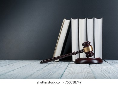Law concept - Open law book with a wooden judges gavel on table in a courtroom or law enforcement office on blue background. Copy space for text