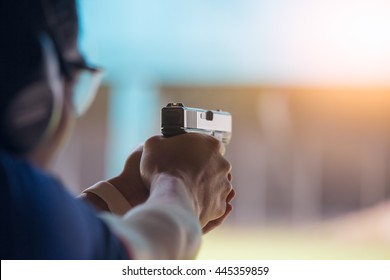 law enforcement aim pistol by two hand in academy shooting range in flare and vintage color, focus at rear gun sight