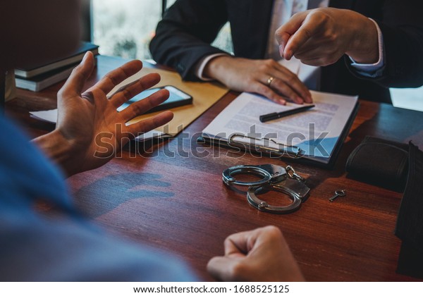 Law enforcement officer interrogating Criminals\
male with handcuffs in the investigation room Police officer\
interviewing after committed a\
crime